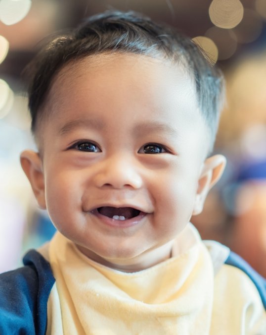 Smiling baby boy with two lower front teeth