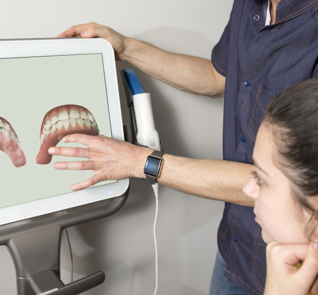 Dentist showing a patient digital scans of their teeth on computer monitor