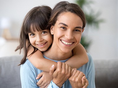 Mom and daughter smiling together