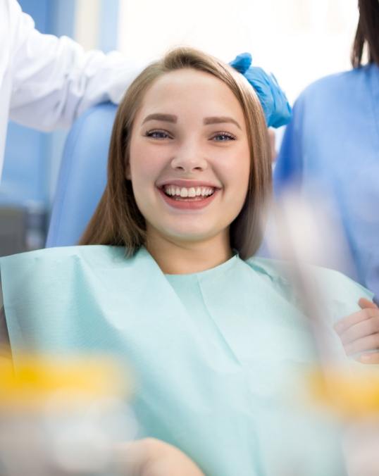 Young woman grinning while sitting in dental chair